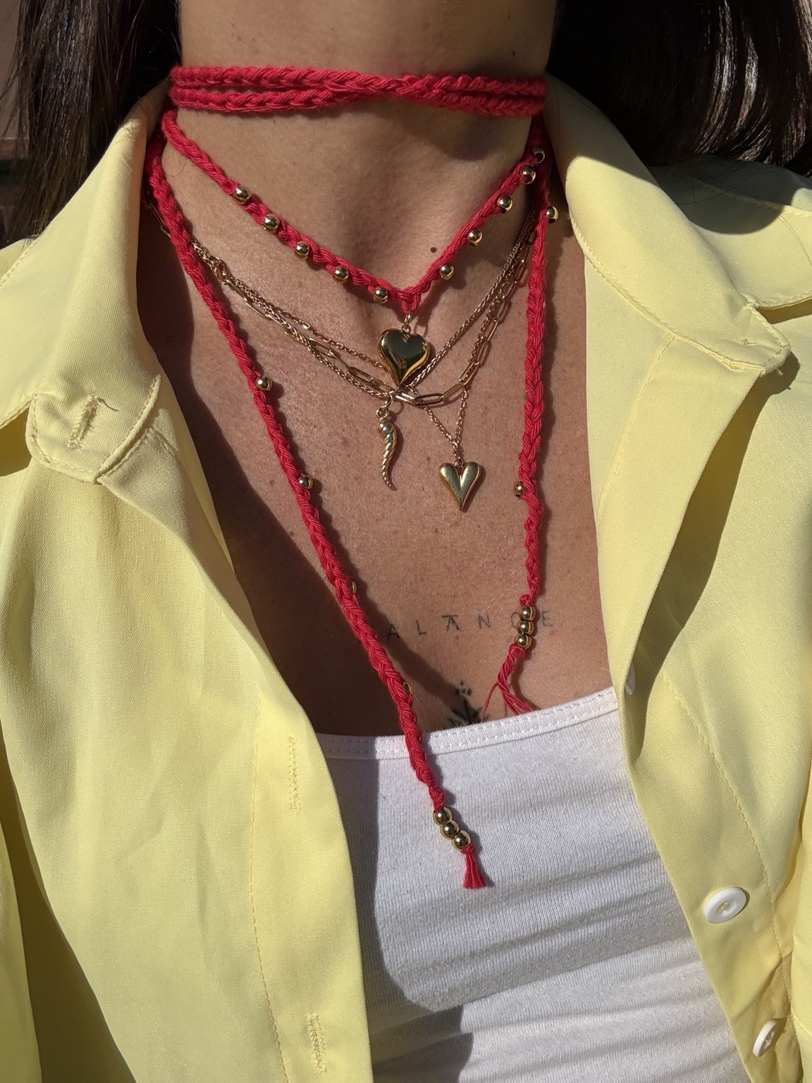 Collana crochet rossa con charms dorati, indossata