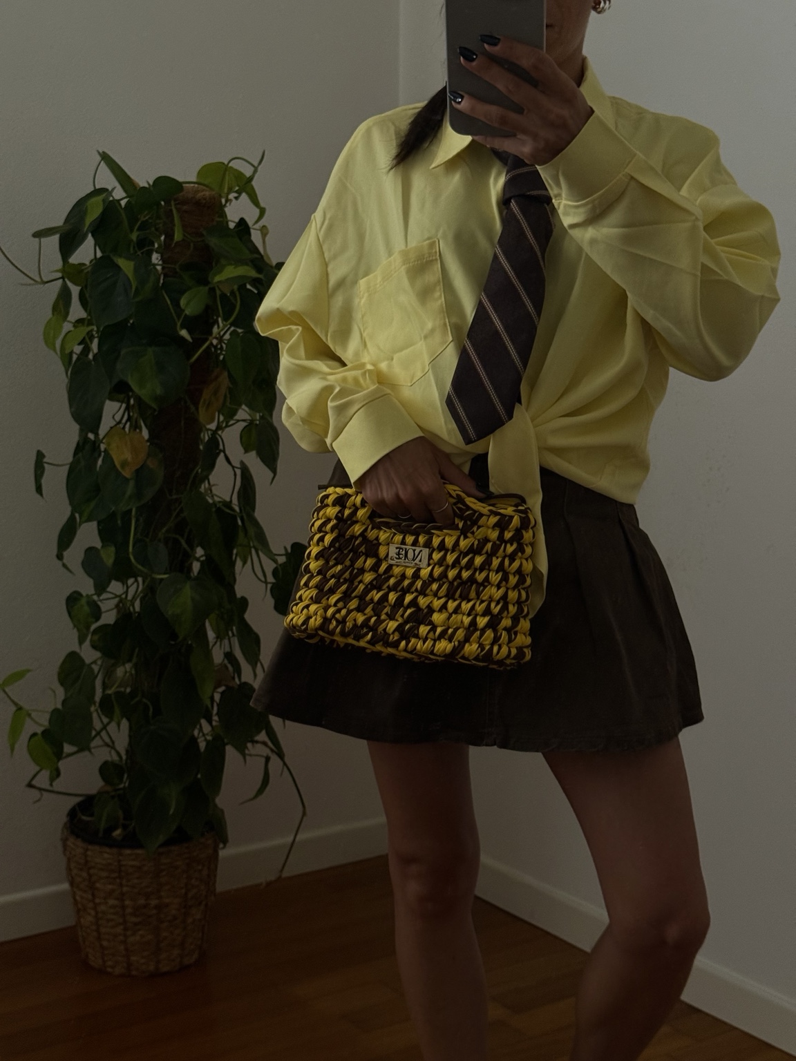 Stefania con camicia gialla, cravatta e borsa crochet gialla e marrone
